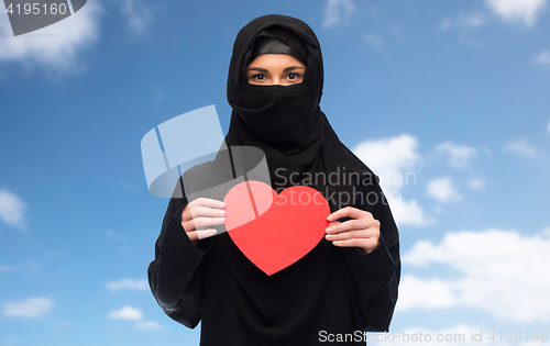 Image of muslim woman in hijab holding red heart