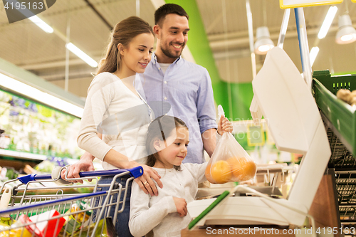 Image of family weighing oranges on scale at grocery store