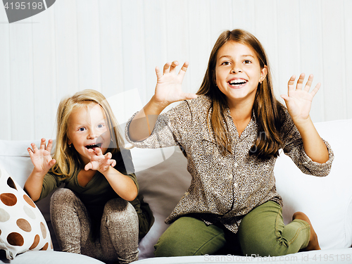 Image of two cute sisters at home playing