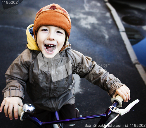 Image of little cute real boy on bicycle smiling close up emotional posing autumn street, lifestyle people concept