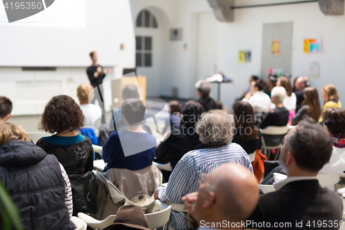 Image of Woman giving presentation in lecture hall at university.