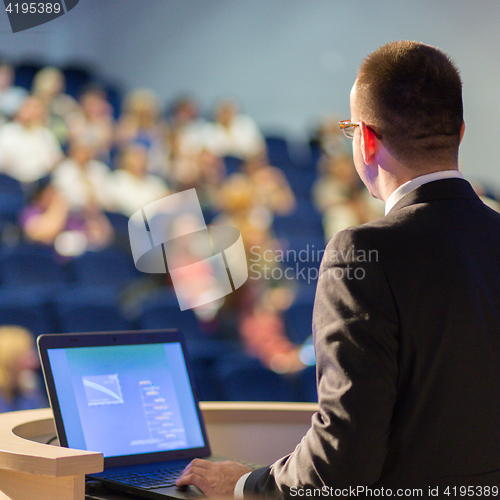 Image of Public speaker giving talk at business event.