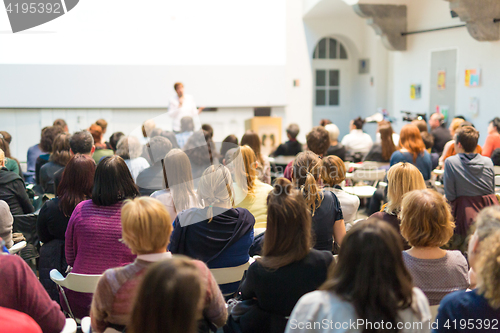 Image of Woman giving presentation in lecture hall at university.