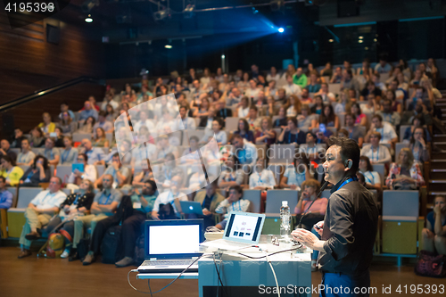 Image of Public speaker giving talk at Business Event.