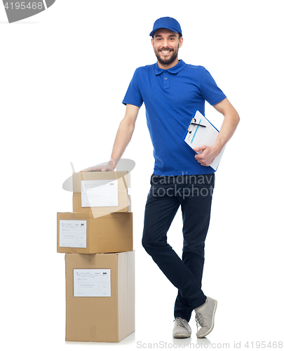 Image of happy delivery man with parcel boxes and clipboard