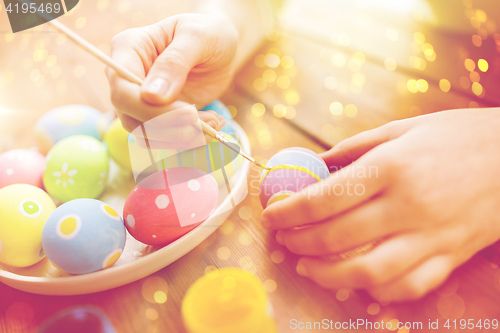 Image of close up of woman hands coloring easter eggs