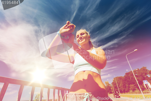 Image of happy woman with heart rate watch and earphones