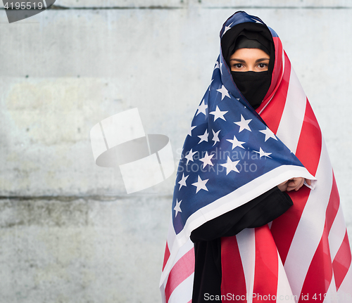 Image of muslim woman in hijab with american flag