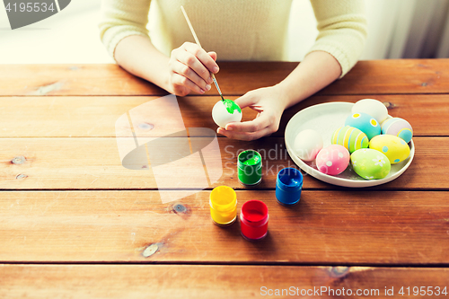 Image of close up of woman hands coloring easter eggs