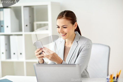 Image of businesswoman with smartphone at office