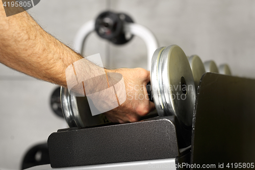 Image of Gym, dumbbells. Trainer in the gym, training with weights