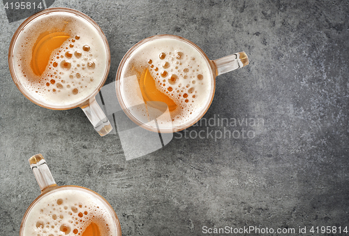 Image of beer mugs on gray table