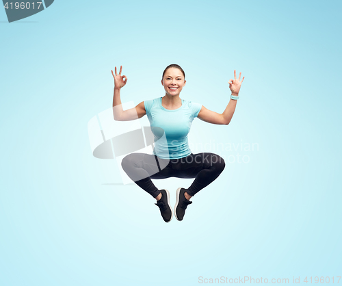 Image of happy smiling sporty young woman jumping in air