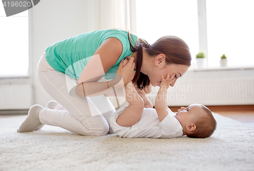 Image of happy mother playing with baby at home