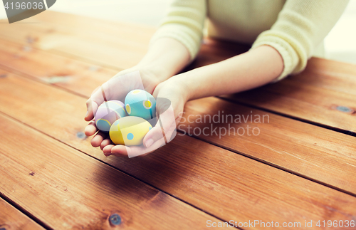 Image of close up of woman hands with colored easter eggs