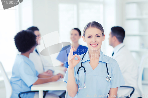 Image of happy doctor over group of medics at hospital