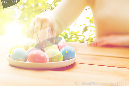 Image of close up of woman hands with colored easter eggs