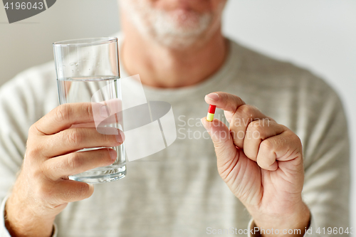 Image of close up of hands with medicine pills and water