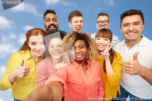 Image of international group of happy people taking selfie