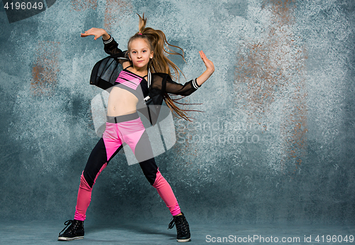 Image of Young girl break dancing on wall background.