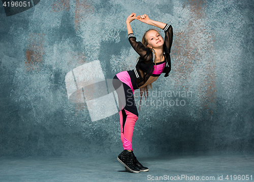 Image of Young girl break dancing on wall background.