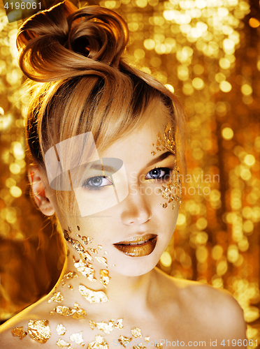Image of beauty blond woman with gold creative make up, bokeh on yellow background 