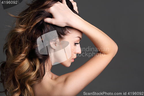 Image of Portrait of a woman with beautiful long hair on a black background