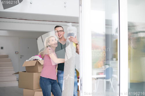 Image of couple carrying a carpet moving in to new home