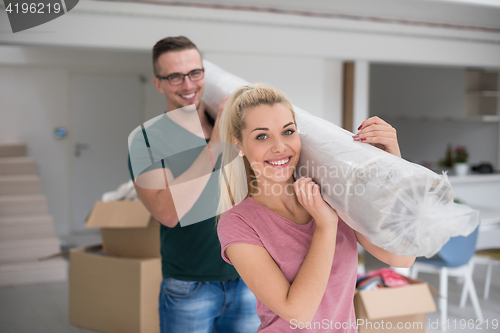 Image of couple carrying a carpet moving in to new home