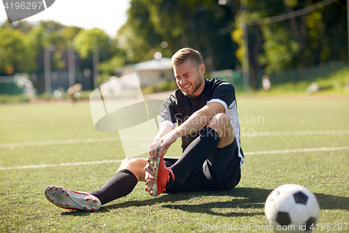 Image of injured soccer player with ball on football field