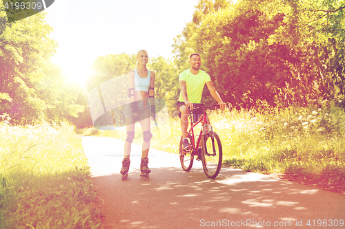 Image of happy couple with rollerblades and bicycle riding