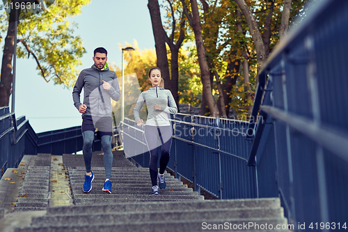 Image of couple running downstairs in city