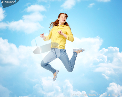 Image of smiling young woman jumping in air