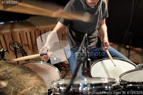 Image of male musician playing drums and cymbals at concert