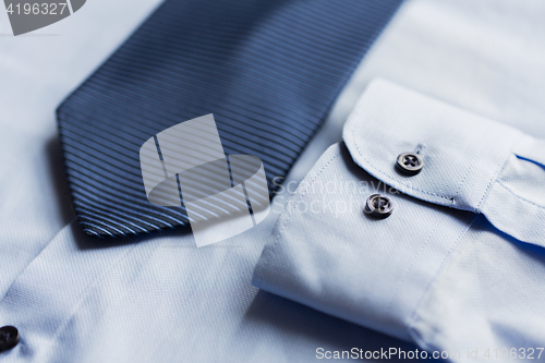 Image of close up of shirt and blue patterned tie