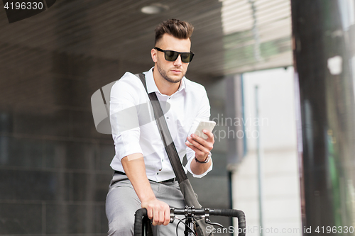 Image of man with bicycle and smartphone on city street