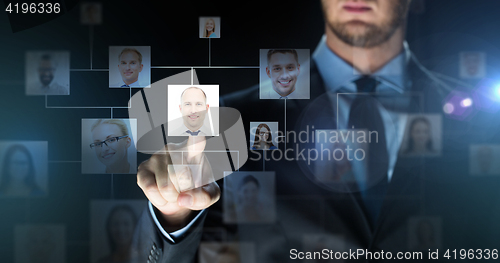 Image of businessman touching virtual screen with contacts