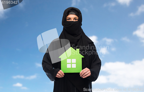 Image of muslim woman in hijab with green house over white