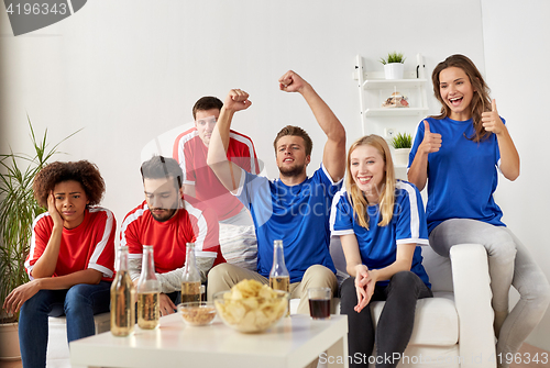 Image of friends or football fans watching soccer at home