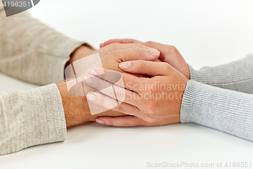 Image of close up of old man and young woman holding hands