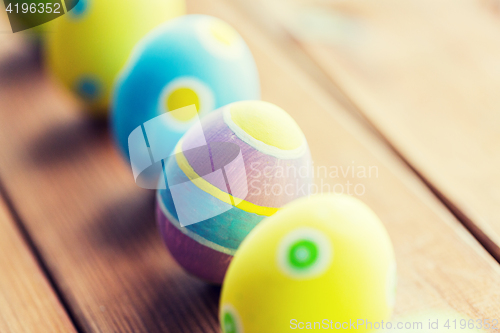 Image of close up of colored easter eggs on wooden surface