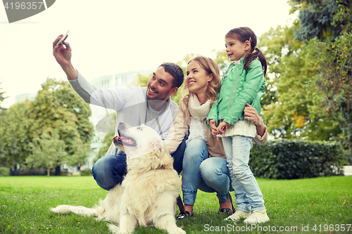 Image of happy family with dog taking selfie by smartphone