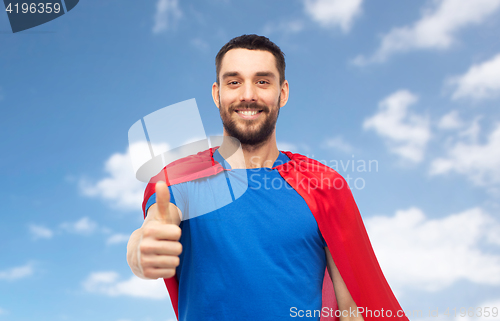 Image of happy man in red superhero cape showing thumbs up