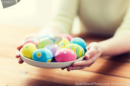 Image of close up of woman hands with colored easter eggs