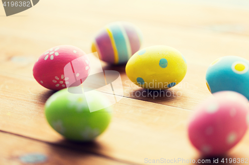 Image of close up of colored easter eggs on wooden surface