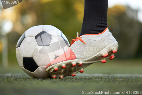 Image of soccer player playing with ball on football field