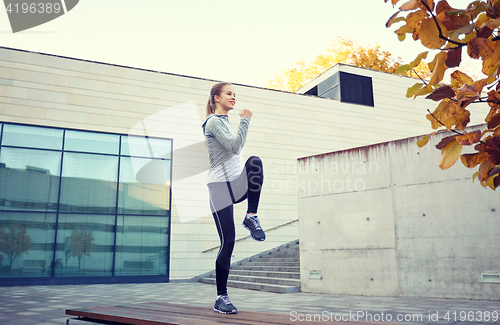 Image of happy woman exercising on bench outdoors