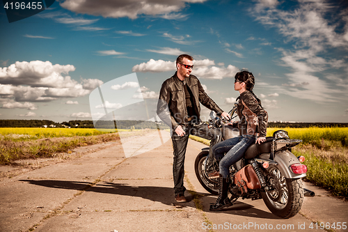 Image of Bikers couple stands on the road