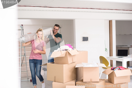 Image of couple carrying a carpet moving in to new home