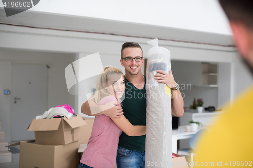 Image of couple carrying a carpet moving in to new home